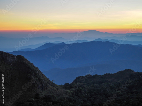 Beautifully graded twilight at Chiang Dao Mountain, the horizon line is orange. Many mountains are dark blue and light. © aeysiriamnat