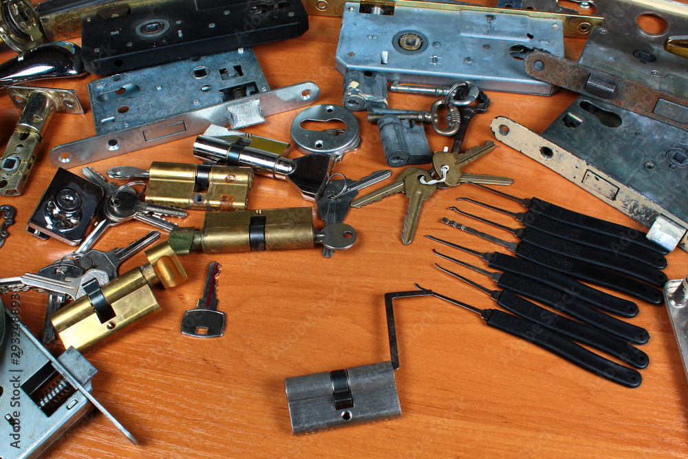 Locksmith workshop. Keys, locks and picklocks on table Locksmith workshop. Keys, locks and picklocks on table
