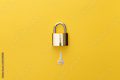 top view of padlock and key on yellow background photo