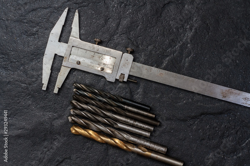 Measuring tool. Vernier caliper on black stone. Background, texture. Close-up © Александр Бутылов