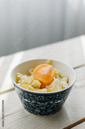 cheese and potato eggs in a bowl.  fried potatoes with fried eggs, rustic breakfast