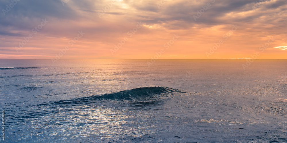 Beautiful ocean wave breaking at sunset
