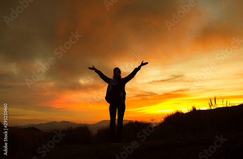 Hiker on a mountain facing the sunset view feeling free and happy.  © kieferpix
