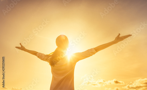Carefree woman outdoors with arms outstretched feeling happy and free. 
