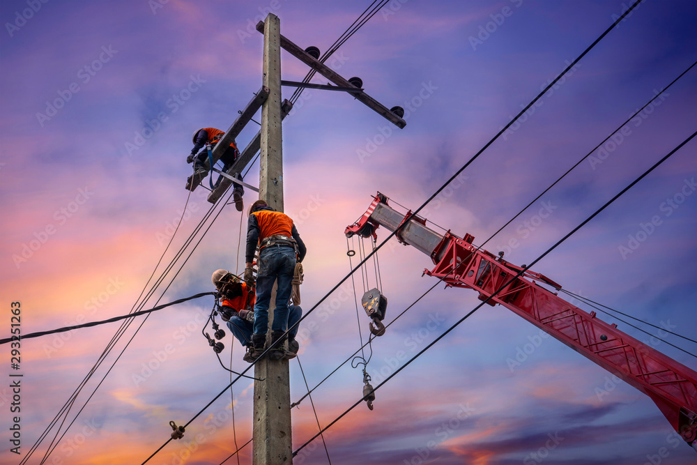 Electrician lineman with cranes and hoists repairman worker at climbing work on electric post power pole Electrician lineman with cranes and hoists repairman worker at climbing work on electric post power pole