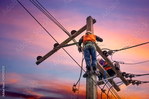 Electrician lineman repairman worker at climbing work on electric post power pole