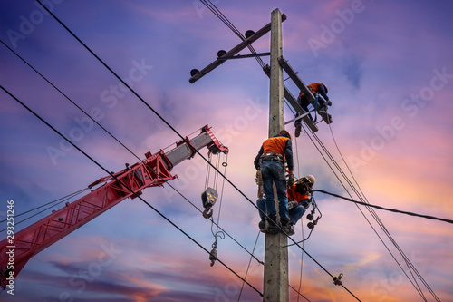 Electrician lineman with cranes and hoists repairman worker at climbing work on electric post power pole