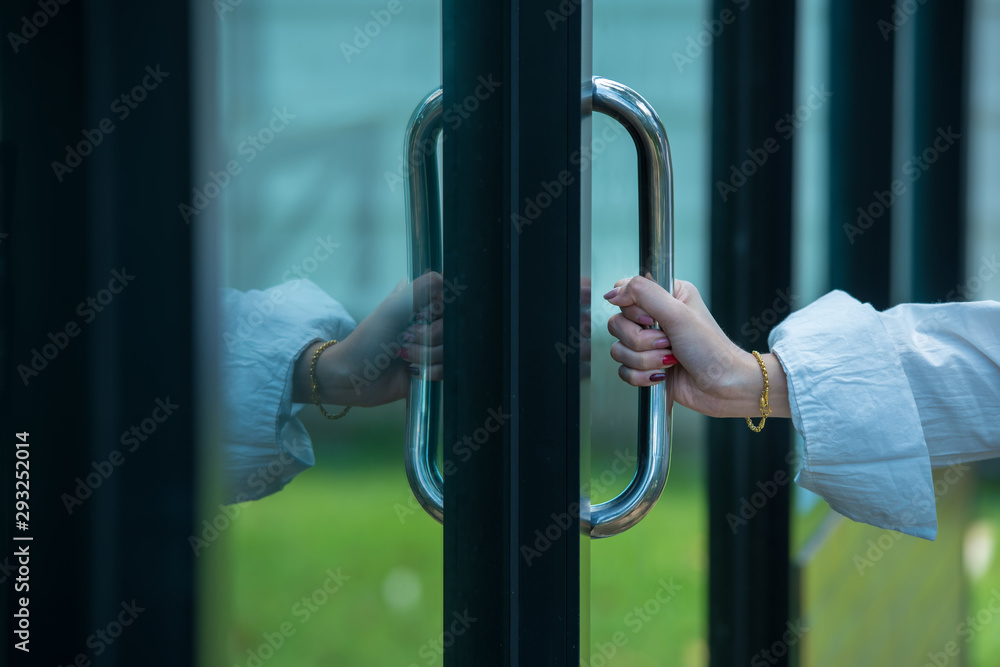 The hands of business women Opening the door to enter the coffee shop The hands of business women Opening the door to enter the coffee shop
