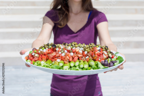 Showing a bowl with salad outdoors in a sunny day.