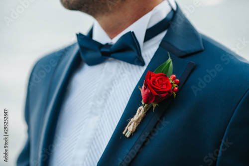 Hands of wedding groom in a white shirt dress cufflinks. Boutonnière. groom buttoning the front of his jacket