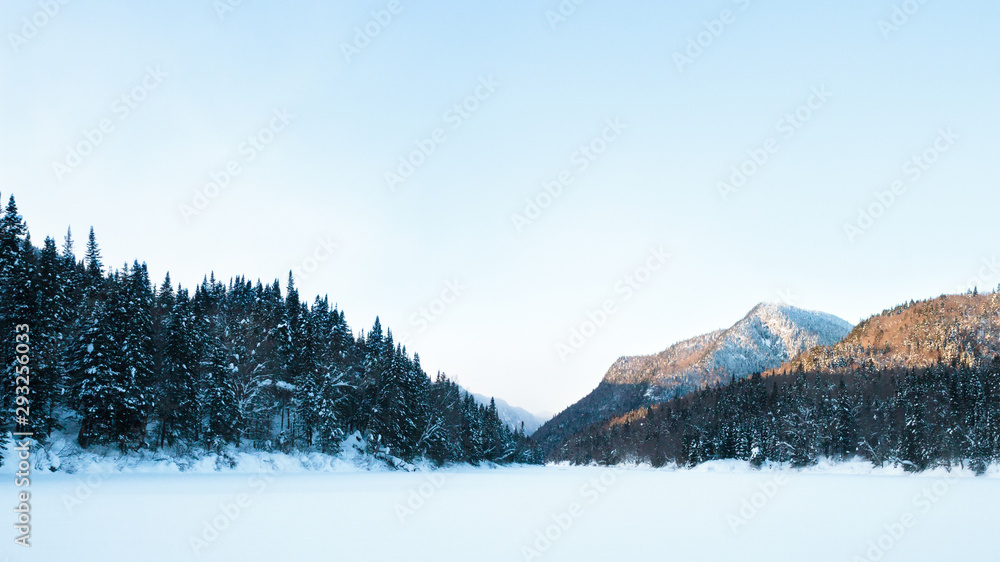 Fototapeta premium Jacques-Cartier National Parc, Qc. Canada. View of the Valley in winter from the covered river 16x9. Vallée de la Jacques-Cartier en hiver avec montagnes 16x9