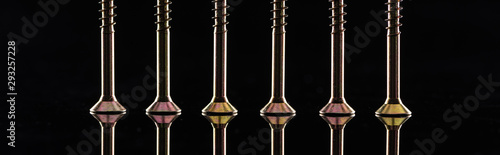 panoramic shot of new shiny metallic screws row isolated on black