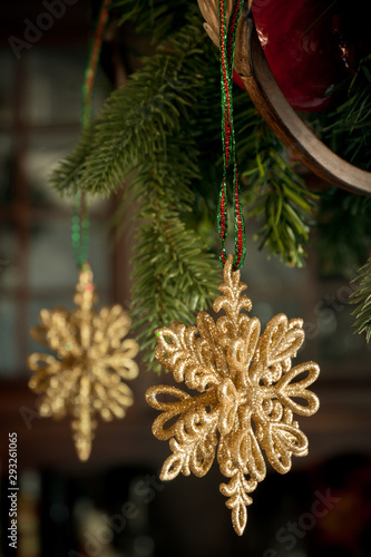 Sparkly, gold hanging christmas ornament from ribbon with green wreath
