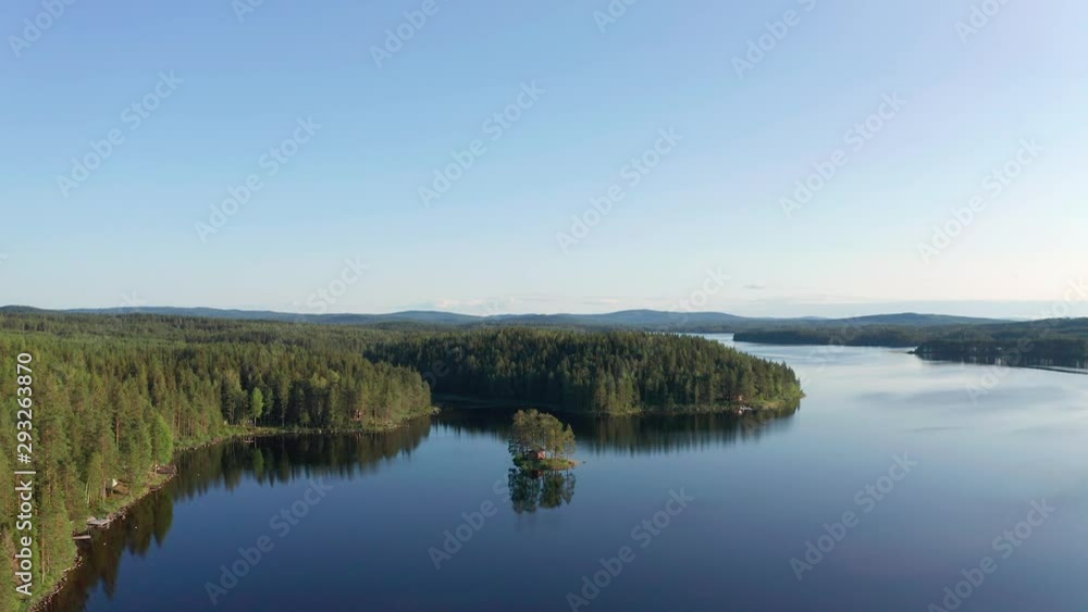 Drone shot of crystal clear lake in Sweden inland surrounded by deep forest landscape Drone shot of crystal clear lake in Sweden inland surrounded by deep forest landscape
