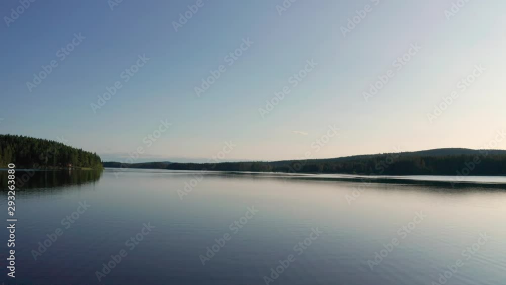 Drone shot of crystal clear lake in Sweden inland surrounded by deep forest landscape Drone shot of crystal clear lake in Sweden inland surrounded by deep forest landscape