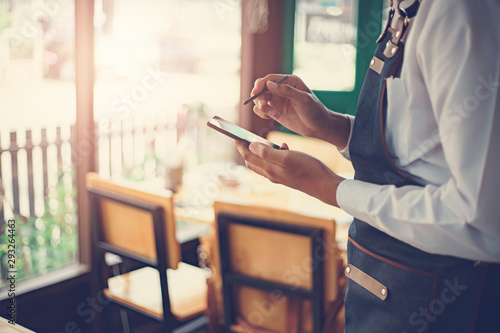 Wallpaper Mural Waiter using touch pad or smart phone to send customer order in the restaurant. Modern wireless technology for retaurant or coffee shop. Torontodigital.ca