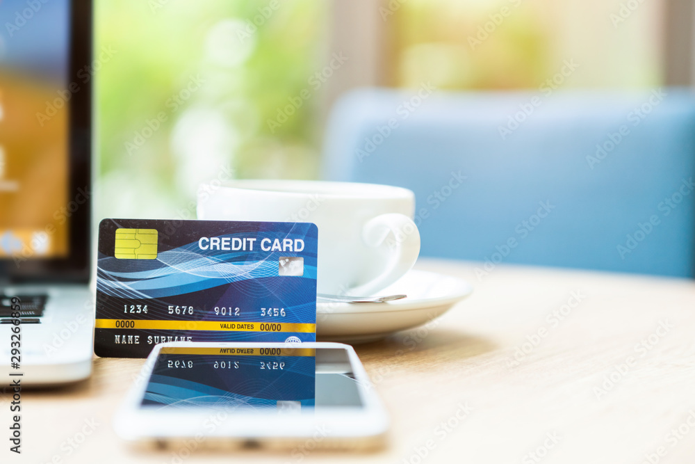 Credit card of laptop computer,smartphone and coffee cup on wooden table of In the coffee shop background,Online banking Concept Credit card of laptop computer,smartphone and coffee cup on wooden table of In the coffee shop background,Online banking Concept