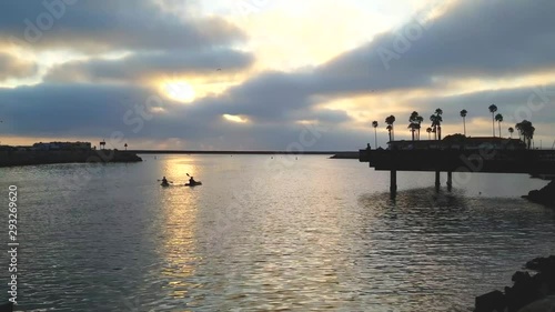 Wallpaper Mural Two friends paddling out to sea in canoes with a stormy sunset and mercury-colored water. Torontodigital.ca