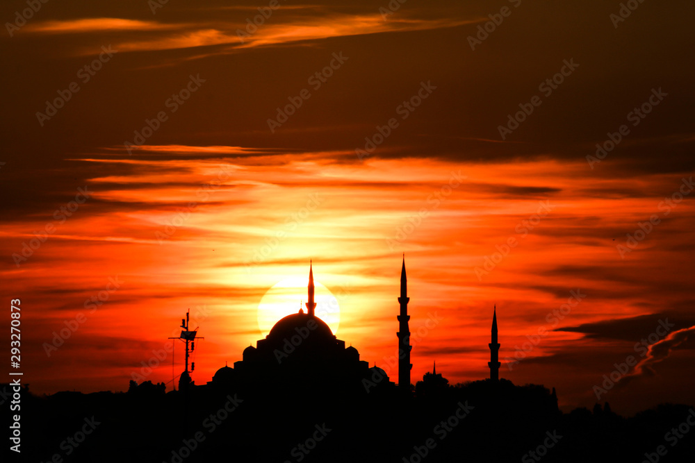 Cityscape of Istanbul with silhouettes of ancient mosques and minarets at sunset. Panoramic view, The Maiden's Tower, Galata Tower, Hagia Sophia, The Blue Mosque and Topkapı Palace in Istanbul.