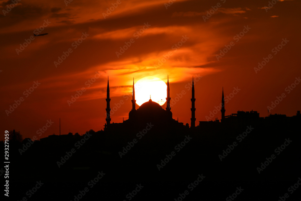 Cityscape of Istanbul with silhouettes of ancient mosques and minarets at sunset. Panoramic view, The Maiden's Tower, Galata Tower, Hagia Sophia, The Blue Mosque and Topkapı Palace in Istanbul.