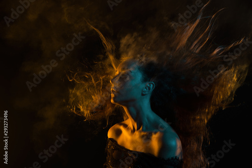 Beautiful woman with long hair in smoke