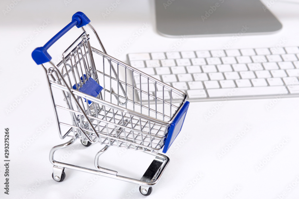 concept of online shopping cart and computer on white background concept of online shopping cart and computer on white background