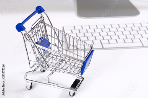 concept of online shopping cart and computer on white background