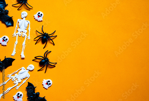 Halloween holiday concept, Bats, white skeletons, black spiders and tiny ghost in orange background with copy space for text, Top flat view wallpaper