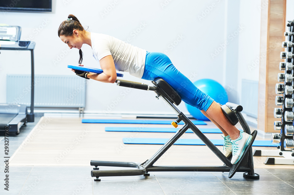Fototapeta premium personall trainer work in gym. hyperextension exercise