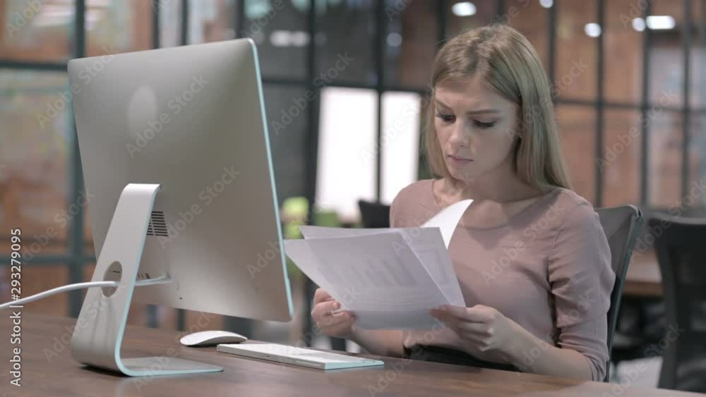 Ambitious Woman Reading Document on Office Desk Ambitious Woman Reading Document on Office Desk