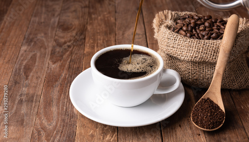 Coffee cup,coffee ground and coffee beans in burlap on wood table