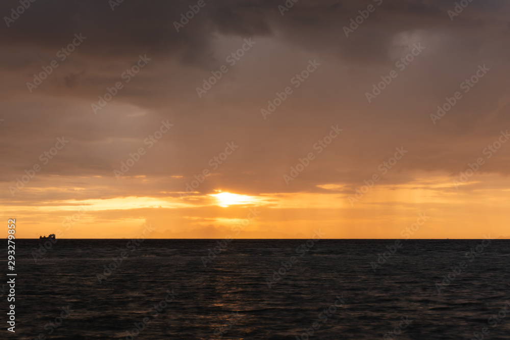 Beautiful beach sunset with big rain clouds and golden light sky  background