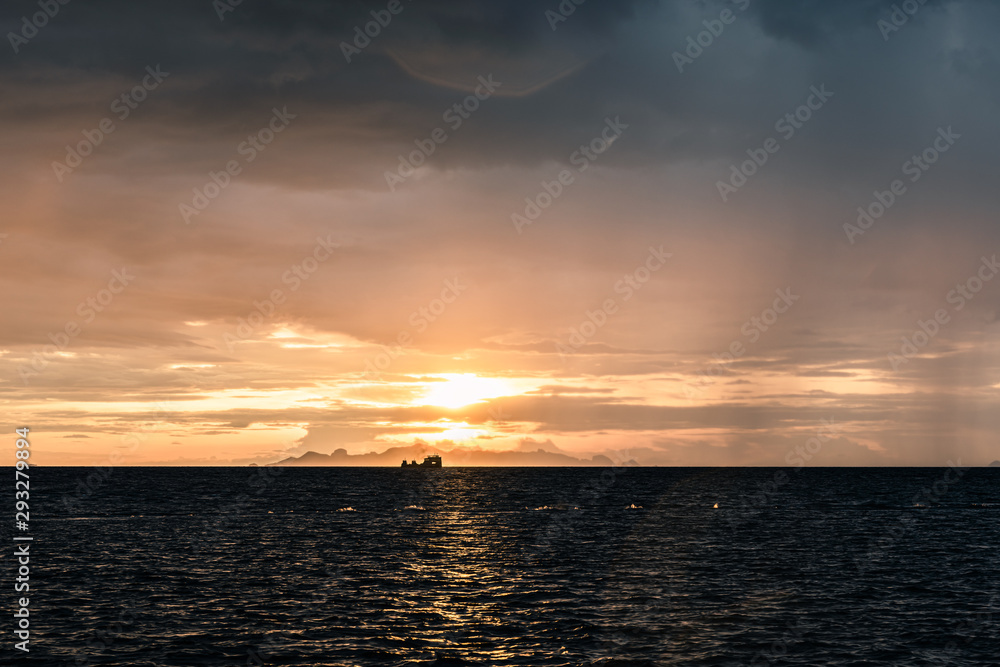 Beautiful beach sunset with big rain clouds and golden light sky  background