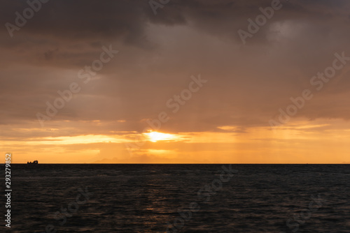 Beautiful beach sunset with big rain clouds and golden light sky background