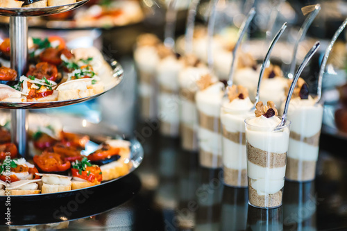 portions of mousse creamy desserts with chocolate. various snacks in three-storey services. Sweets, saltwater, cheese  balls, pickles, cheese tree, chocolate mousse, served on trays