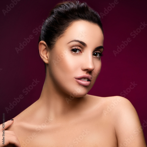 Beauty woman portrait, Sensual lady looking at camera. Perfect skin, nude natural make-up. Dark red background