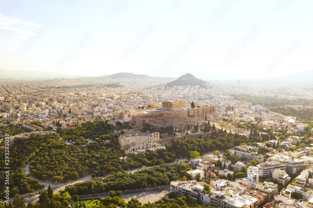 Aerial view of a slide from the drone on the panorama of residential buildings of the city of Athens, on the main symbol of ancient Greece, Acropolis at sunrise. The lights sun. World Heritage sites