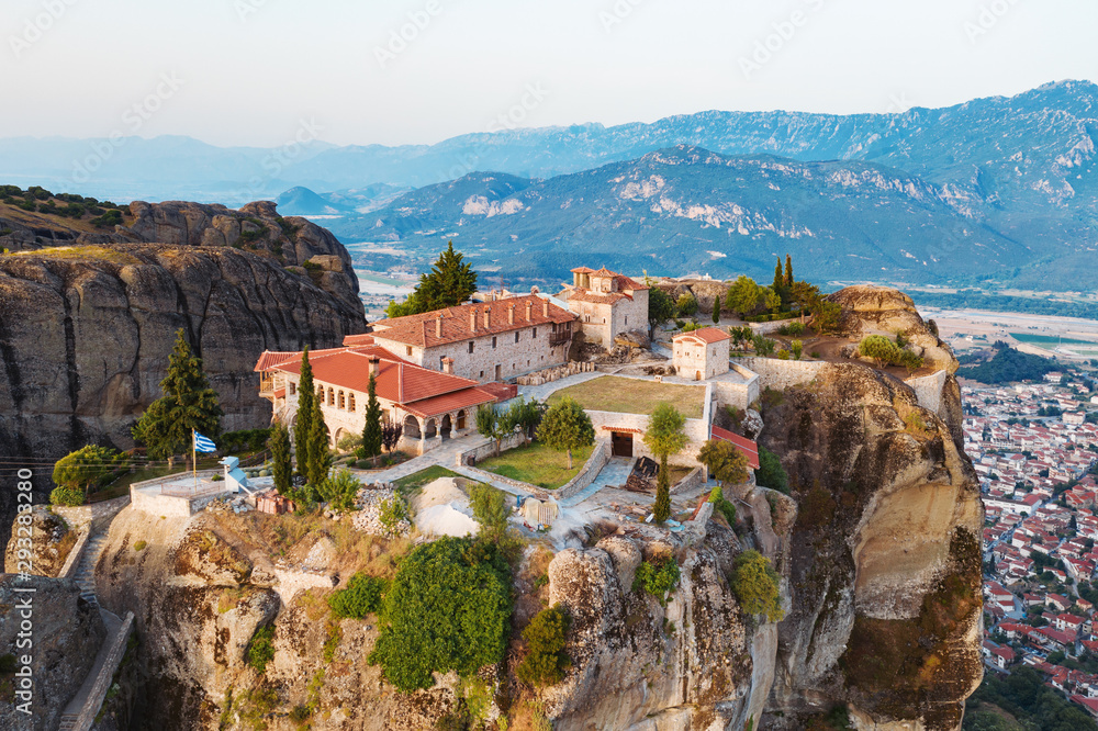 Aerial view of a slide from a drone on a panorama of a mountain range. Kalampaka city, Greece. View of the cliffs of Meteora and the monasteries of Meteora. Many ancient Orthodox monasteries summer