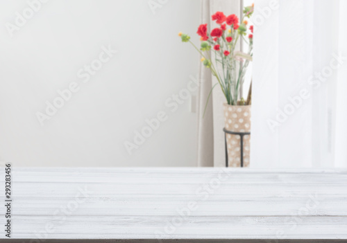 White wood table top with flower pot in living room background © jcsmilly