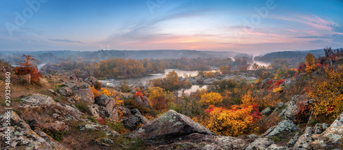 piękny krajobraz jesień z kolorowymi drzewami i mglistą rzeką o zachodzie słońca