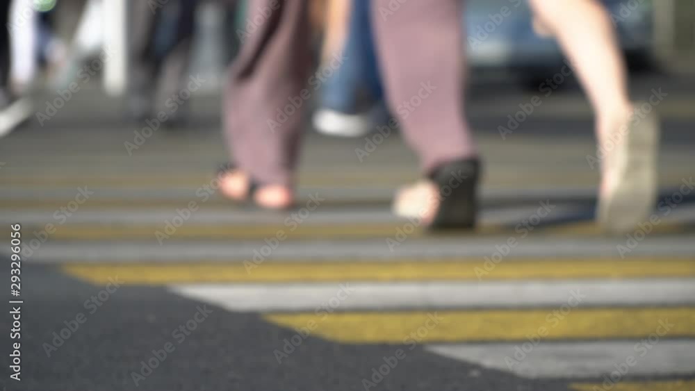 defocused pedestrians move along yellow and white crosswalk defocused pedestrians move along yellow and white crosswalk