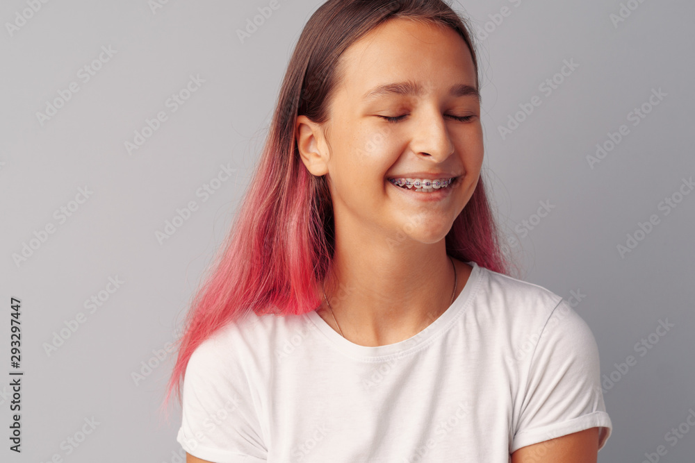 Young girl teenager with pink hair happy and smiling over gray background Young girl teenager with pink hair happy and smiling over gray background