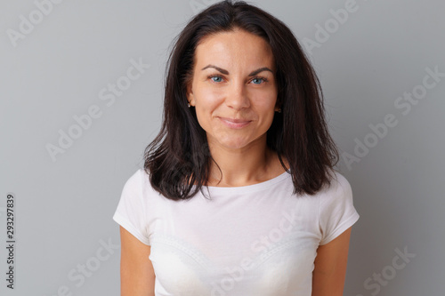 Beautiful woman middle age posing over a grey background