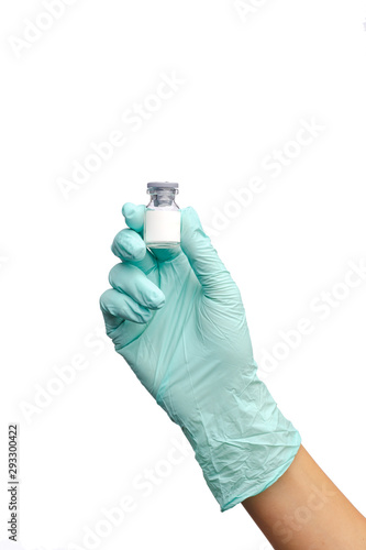 A hand in a blue glove holds a jar of medicine