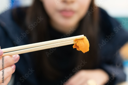 Holding uni sushi in chopsticks. Sea urchin(uni sashimi) ,Japanese food.