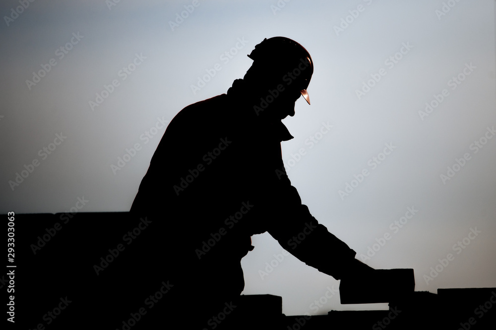 Mason silhouette on construction site during development of the biulding