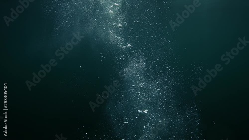 Bubbles rise from the depth to the surface in slow motion. They turbulize and dissolve in water. They pass close to the camera and propagate in defocus.
