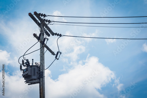 Electric tranformer on the eletric Cement-pole. White clouds and blue sky