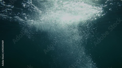 Bubbles rise from the depth to the surface in slow motion. They turbulize and dissolve in water. They pass close to the camera and propagate in defocus.