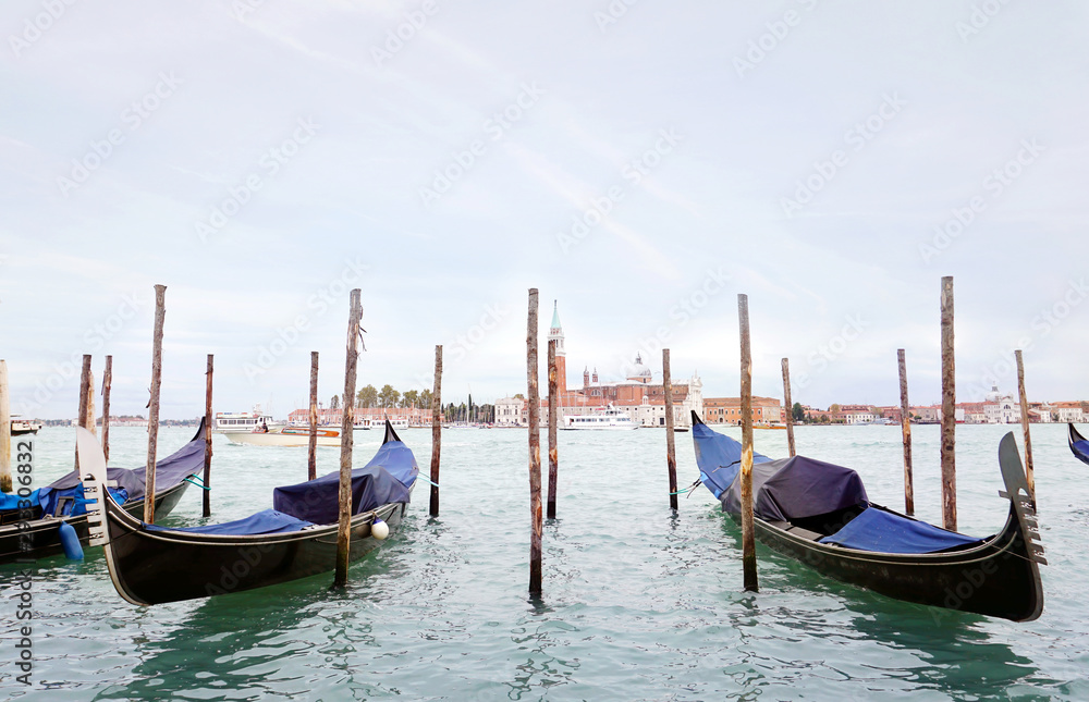 Gondolas in the Venetian lagoon near the promenade in Venice